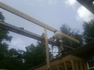 Carpenter setting a ridge beam over a new addition frame — Ice Dam Removal by Roofing Brothers in Arcadia